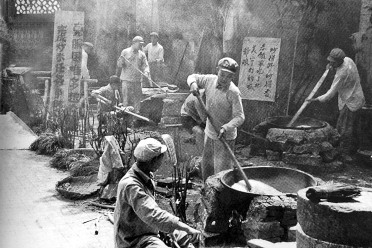 后勤人员在为志愿军炒炒面、炒米。